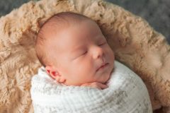 Newborn swaddled in white blanket