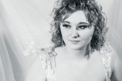 Black and white image of a girl in a  prom dress looking off into the distance